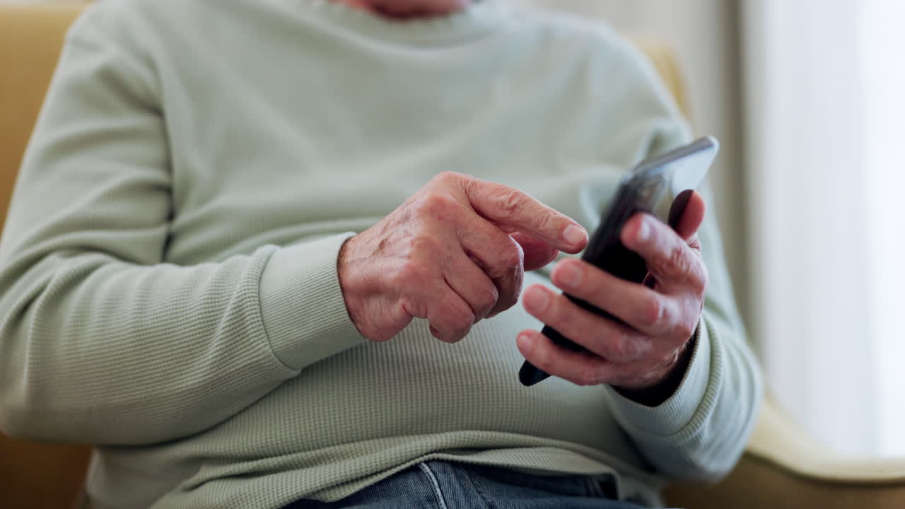 Parkinson, telefono e mani di uomo anziano che digita