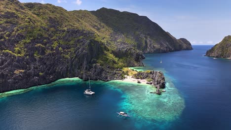 bird's-eye survey of star beach, with a couple of boats in a calm atmosphere in tapiutan island, philippines