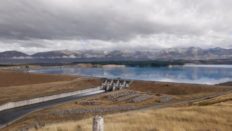 Cinematic-aerial-footage-of-Lake-Pukaki-open-spill-on-calm,-cloudy-morning