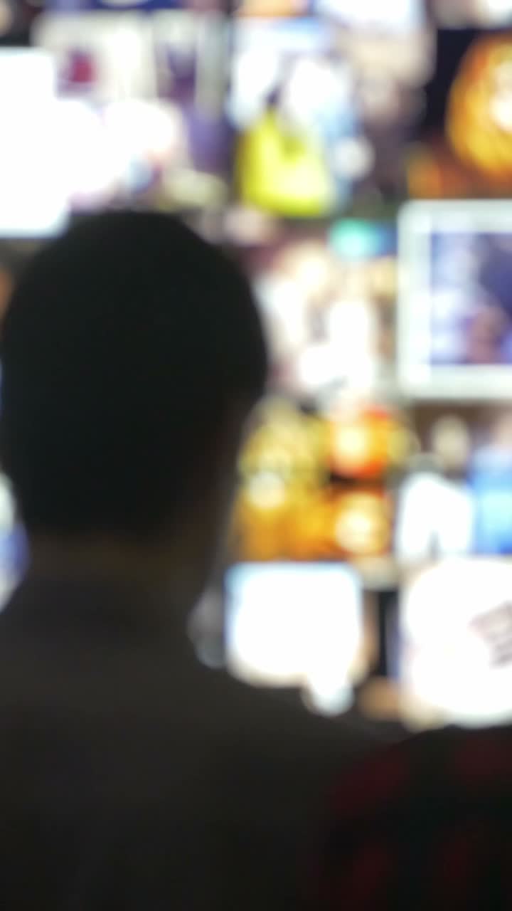 Person watching a wall of television screens