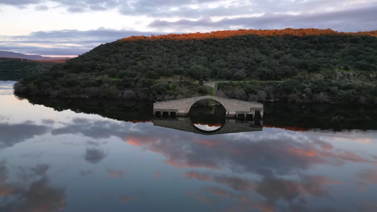 Ripresa drone in hyperlapse del Ponte Romano di El Ponton al tramonto a Guijo de Granadilla, Estremadura. Movimento dinamico su paesaggio storico