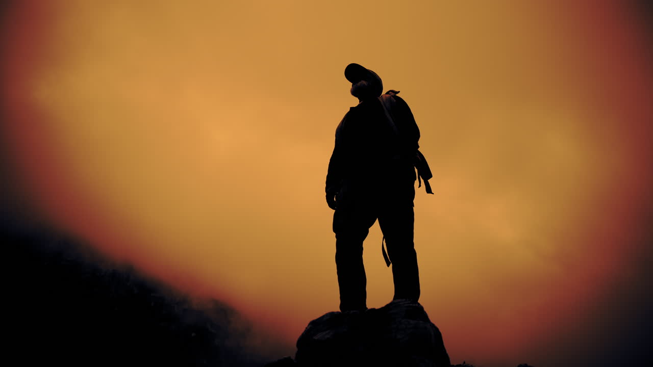 Silhouette of a Hiker on a Mountain at Sunset