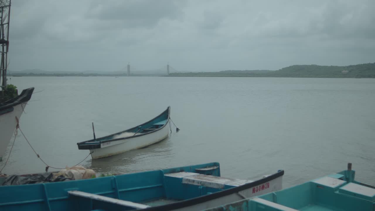 Calm river scene with boats and cloudy sky, feeling of solitude