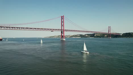 el puente 25 de abril en lisboa con veleros
