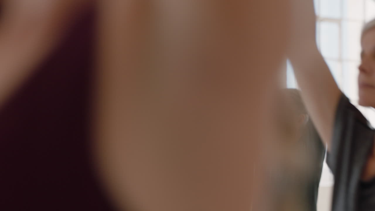 yoga class of healthy mature women practicing prayer pose enjoying relaxing breathing exercise in fitness studio