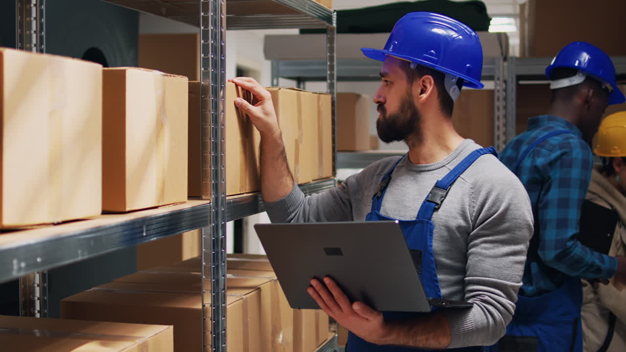 Warehouse workers checking inventory with laptop