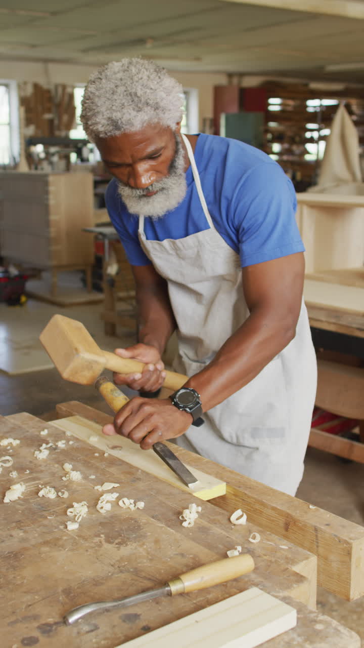 video vertical de un carpintero afroamericano de edad avanzada trabajando en un taller