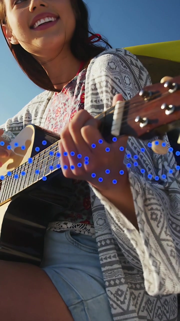 Video vertical: Guitarrista tocando música después de un retroceso de cámara, cantando mientras puntos azules rastrean los acordes