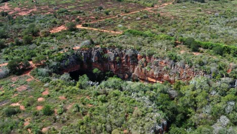 Luftdrohne-Weitwinkelaufnahme-Des-Großen-Lapa-Doce-Höhleneingangs-Aus-Bunten-Felsen-Mit-Einem-In-Sich-Geschlossenen-Regenwald-Darunter-Im-Chapada-Diamantina-Nationalpark-In-Bahia,-Nordostbrasilien