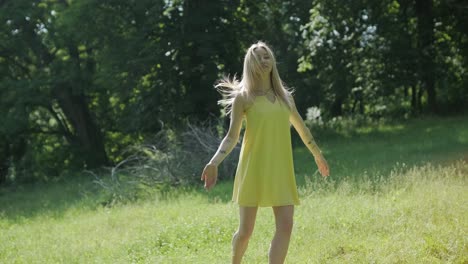 woman in yellow dress dancing gracefully in summer park