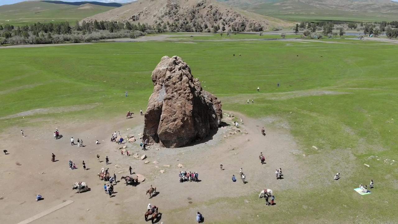 Ilmakuva turisteista vierailemassa suuressa kalliomuodostelmassa Mongolian arolla