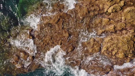 Rocky-cliff-coastline-of-Tenerife-with-foamy-ocean-waves,-aerial-top-down