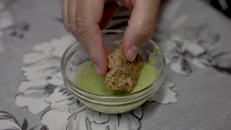 kebab piece being dipped in green mint yogurt dipping sauce