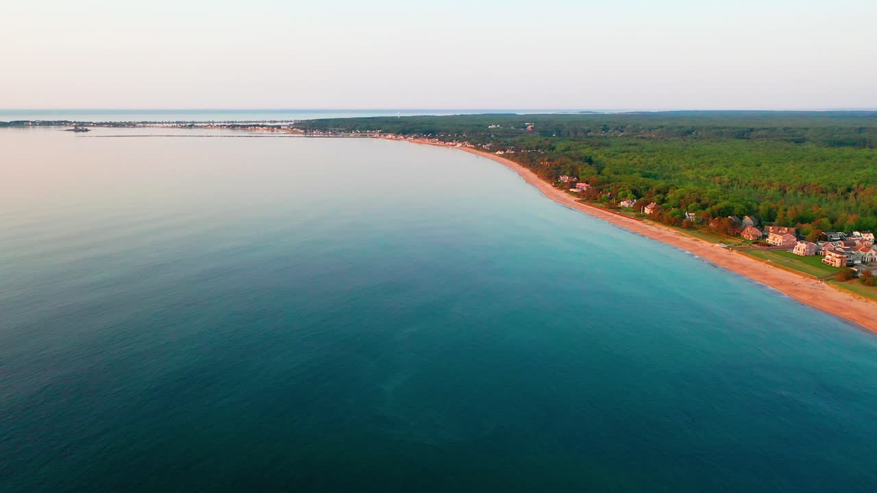 Flying drone view shows deserted beaches of Saco, Maine. Off-season seascape with empty sand, no tourists, vacation homes along the Atlantic Ocean waves. Beautiful coastal scenery for travel lovers.