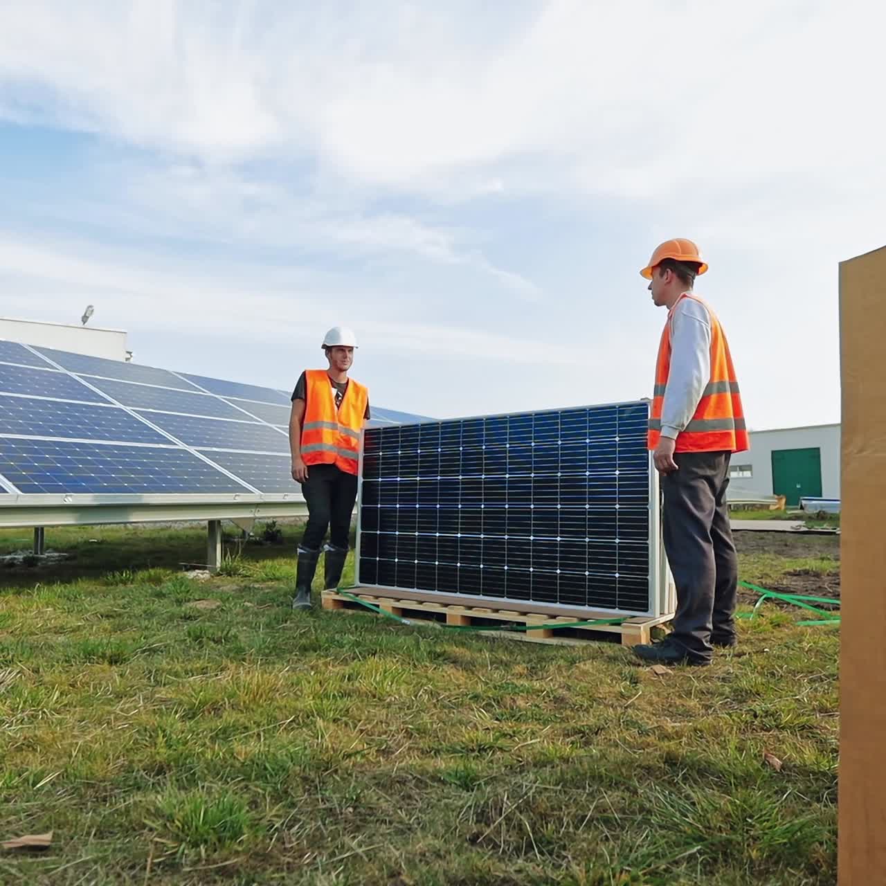 New solar panels on the grass. Workers installing photovoltaic panels for renewable energy. Construction of solar panels for new source of electricity.
