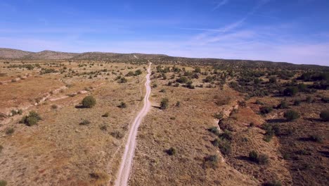 high angle flyover the dirt road that separates the desert grasslands in two