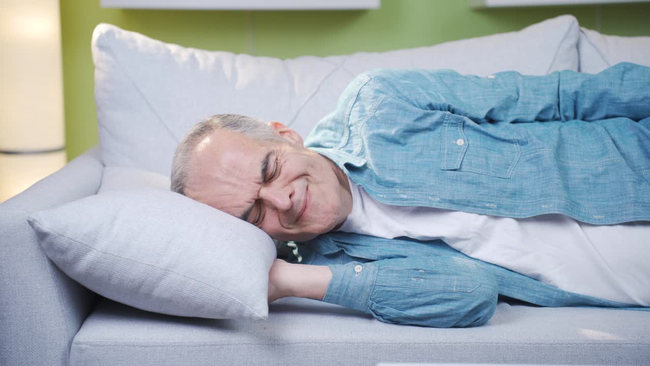 The old man who puts his head on the pillow remembers the past and gets sad.