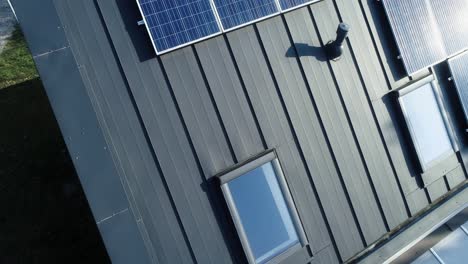 deslizarse sobre una casa nueva con paneles solares rodeada de naturaleza