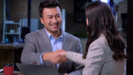 Two colleague teammates celebrate good outcome of sales, check project details start up launch results feel satisfied with success give colleague expressing respect, look happy with effective teamwork