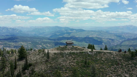 Aerial-moving-over-fire-lookout-tower-on-scenic-mountain-top