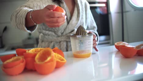 Mujer-Usando-Exprimidor-De-Naranja,-Exprimidor,-Escariador-Preparando-Un-Jugo-De-Naranja-En-Casa