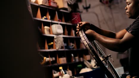 bicycle mechanic fixing spokes wheel in repair workshop