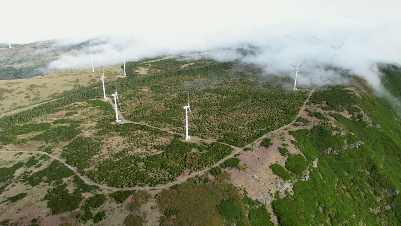 무인기 비행은 구름이 많은 울창한 마데라 산 언덕에서 회전하는 풍력 터빈을 통과합니다.