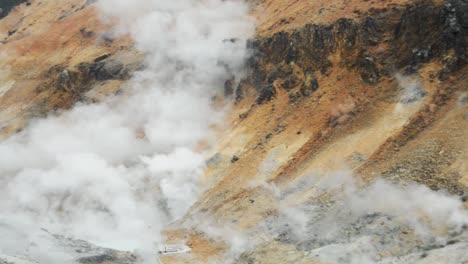 pan left close-up view of the steaming volcanic area at jigokudani , noboribetsu