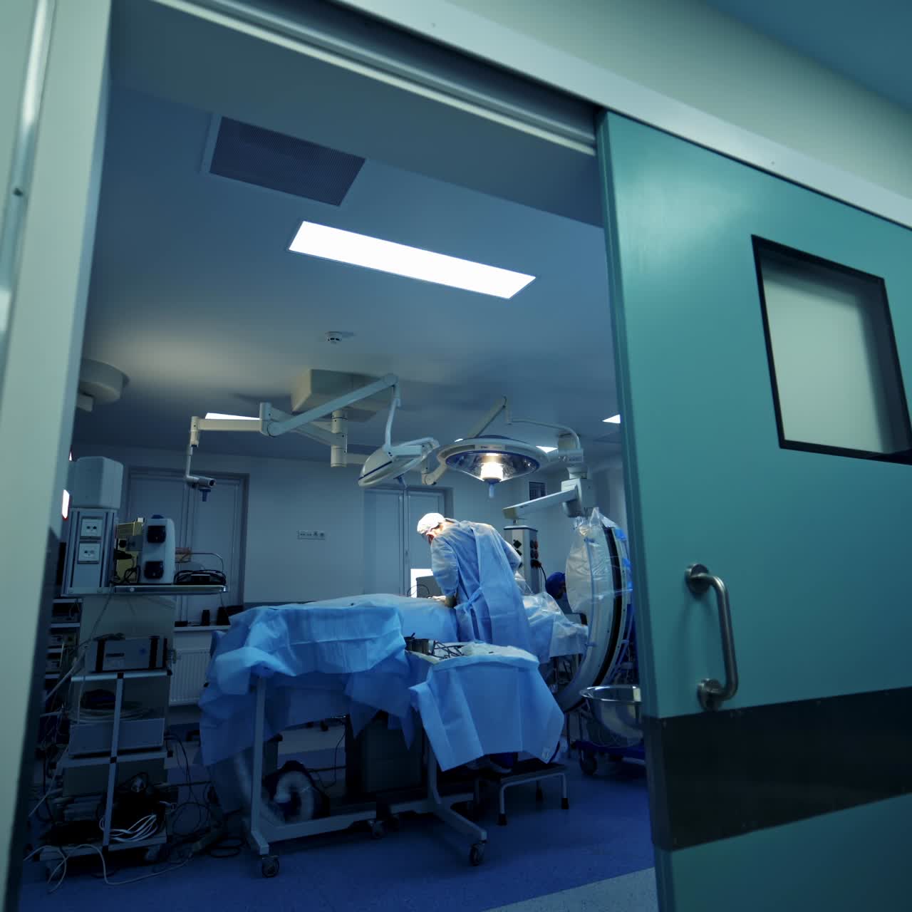 Operation in clinic with modern equipment. Surgery in up to date clinic. Team of doctors in medical masks and uniform