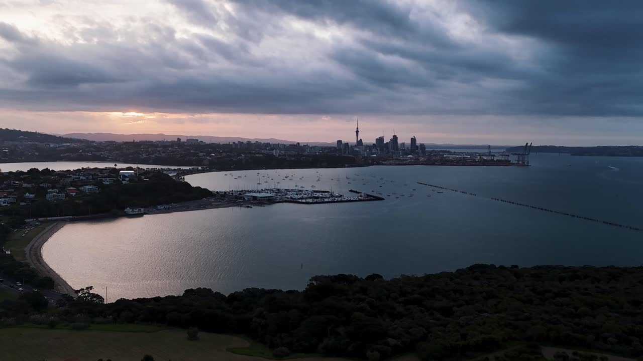 Aerial hyperlapse view of the skyline of Auckland during the sunset with harbor in the foreground
