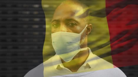 Animation-Der-Belgischen-Flagge,-Die-über-Einem-Afroamerikanischen-Mann-Mit-Gesichtsmaske-In-Der-Stadtstraße-Weht