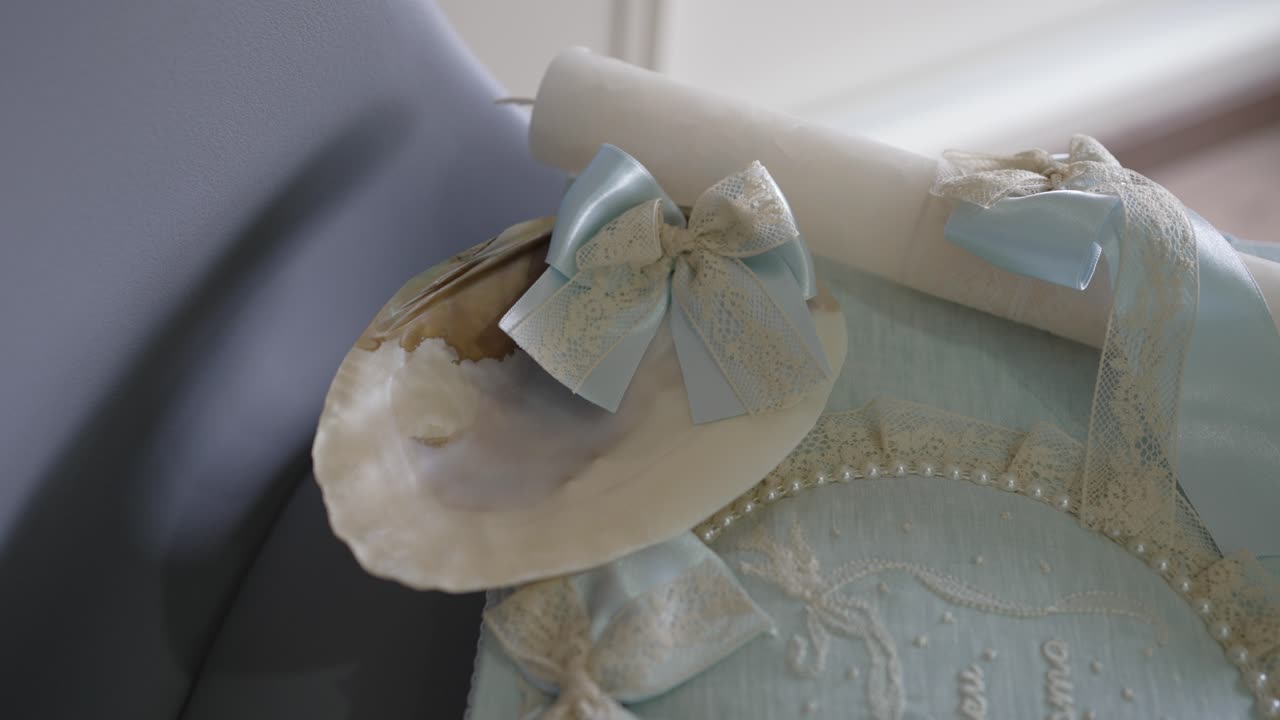 close up of decorated shell with blue lace bow used in baptism ceremony