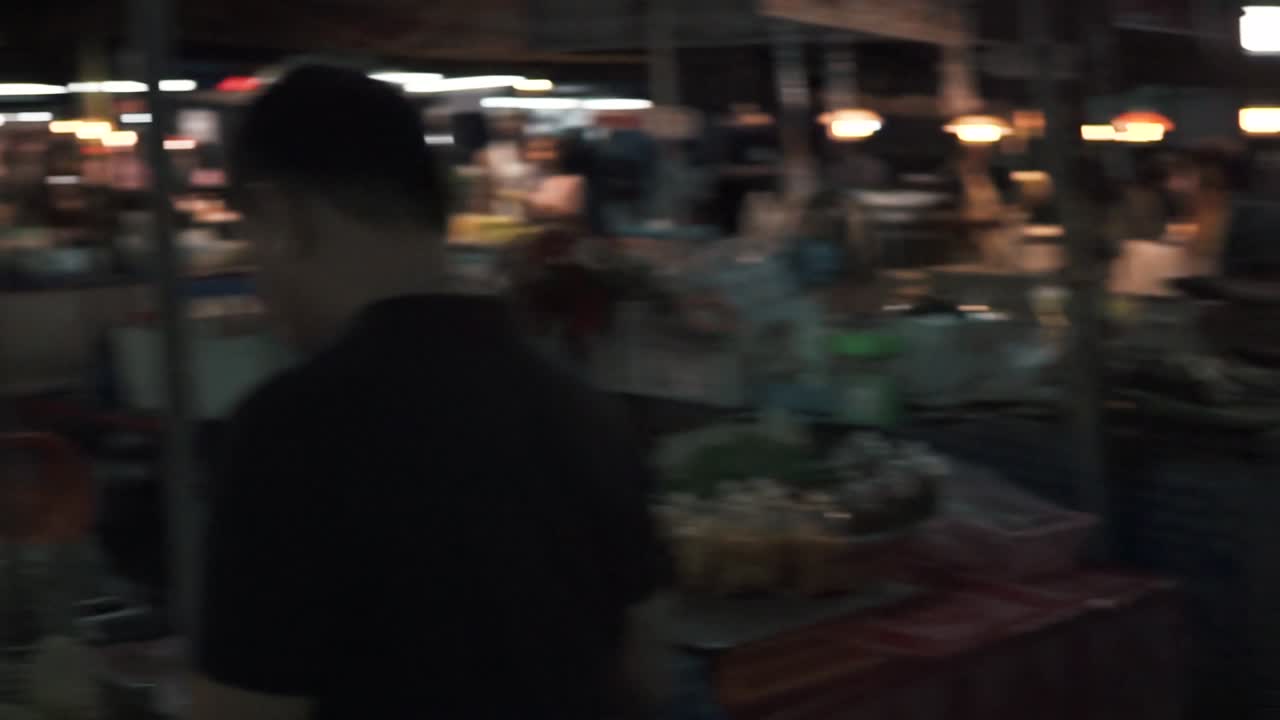 Merchant wrapping flowers for customer in market, Krabi, Thailand, slow motion