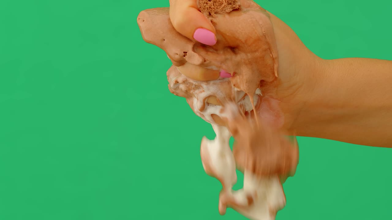 mujer destrozando helado a mano sobre un fondo verde, 4k