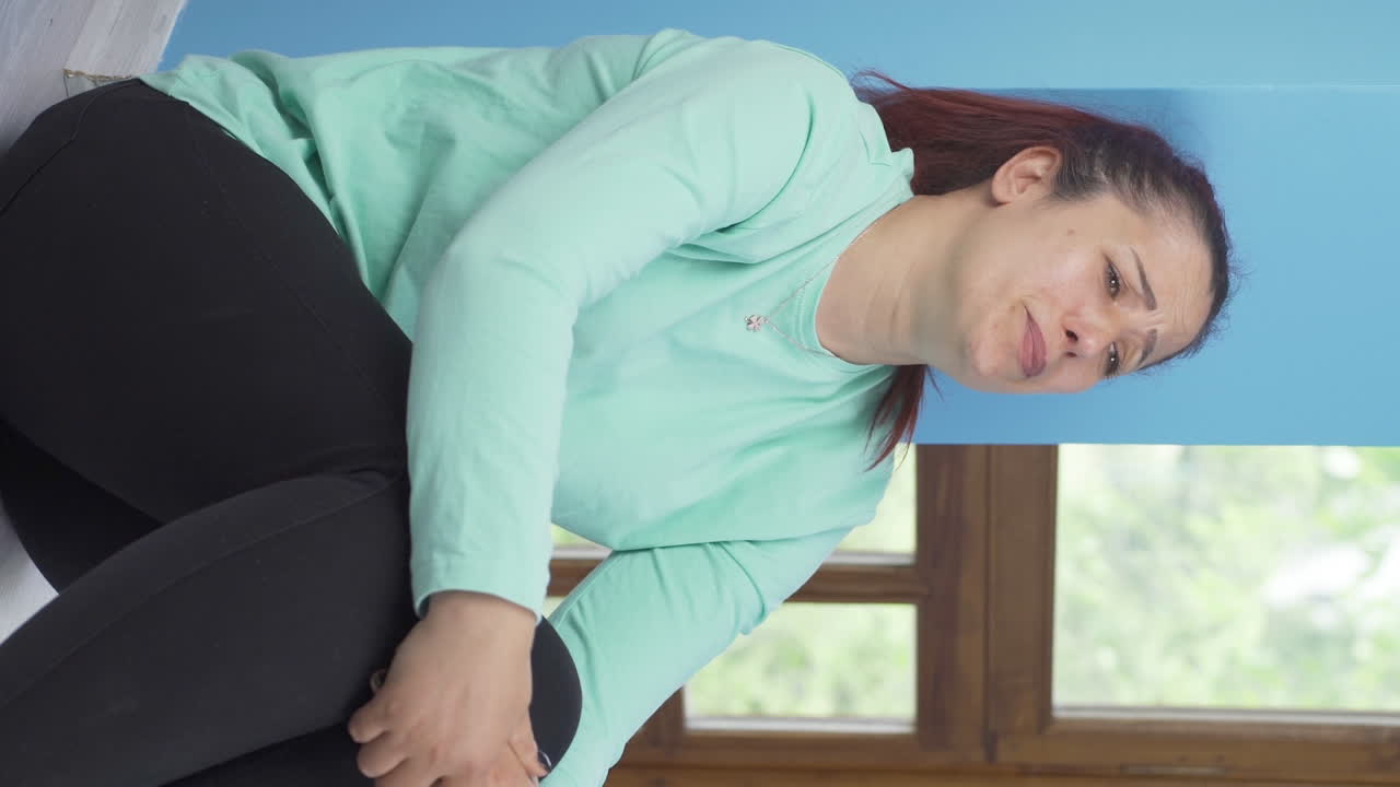 vídeo vertical de la mujer sentada en el suelo está llorando. desanimado.