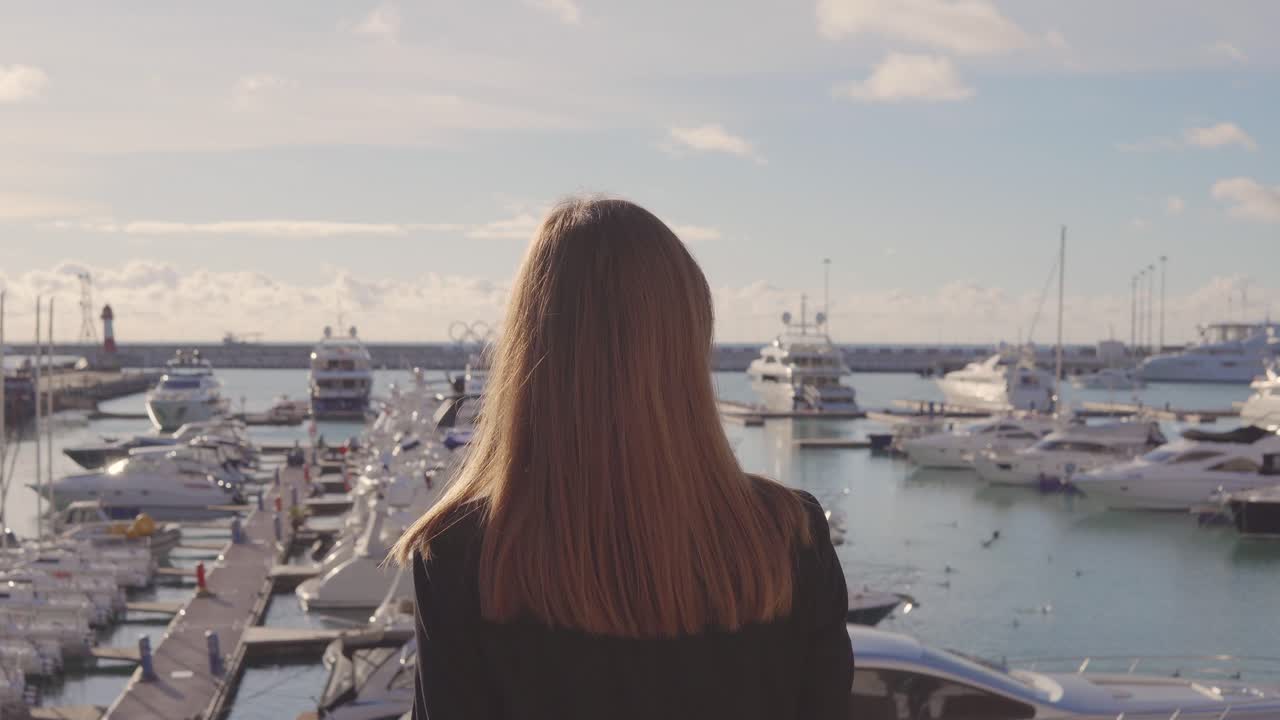 Woman looking at boats in a harbor