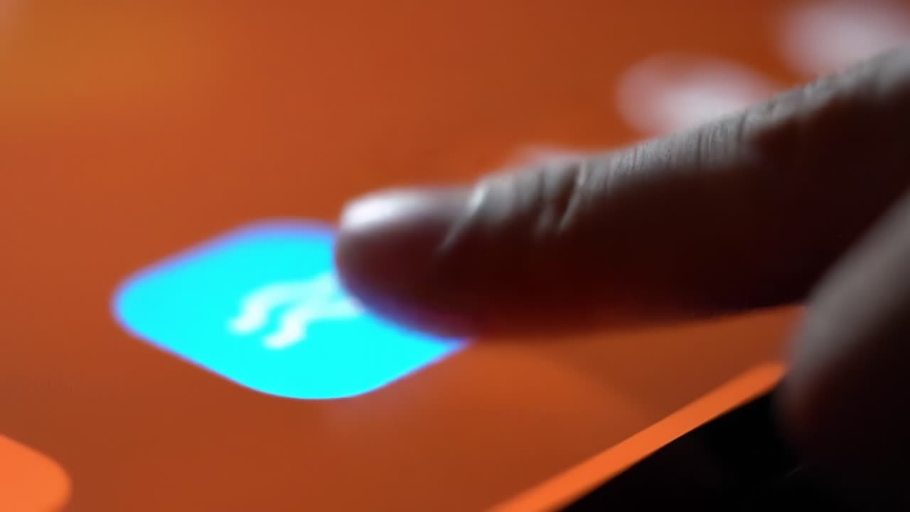 Close-Up Interaction with a Touchscreen Interface: Transition from an Orange Icon to a Blue Icon Reflecting User Engagement in Digital Applications