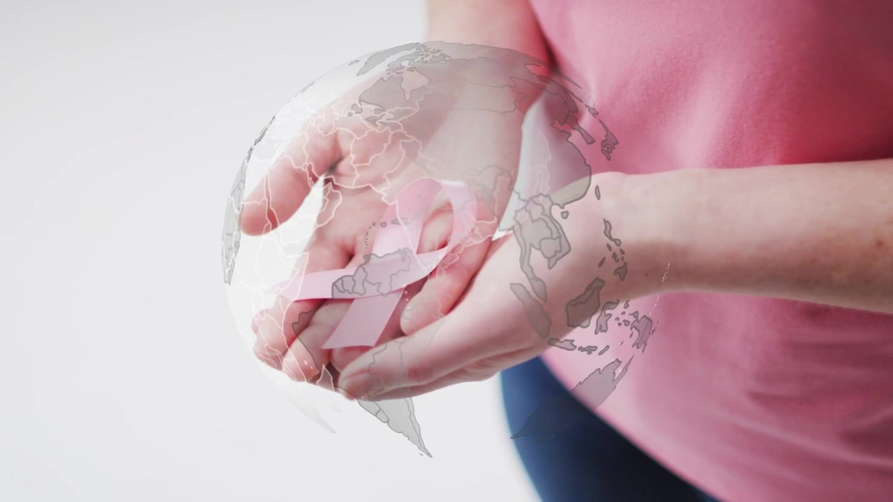 Donna adulta che tiene un nastro rosa, con una grafica del globo che appare e ruota sopra le mani, promuovendo la salute