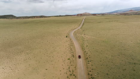 following shot of jeep wrangler travelling off-road through desert landscape in utah, usa