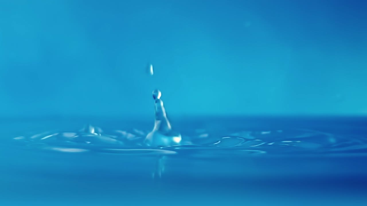 파란색 배경에 떨어지는 물방울과 함께 물 표면의 느린 모션 4k 비디오.