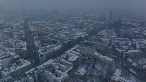 Aerial-panoramic-footage-of-winter-city.-Urban-neighbourhood-with-buildings-sprinkled-with-snowflakes.-Berlin,-Germany