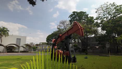 palm leaf sways in wind revealing chemical engineering and geosciences school under tropical sun.