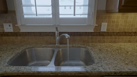 clean kitchen sink tap running water gimbal shot