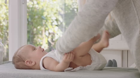 madre feliz cambiando el pañal del bebé cuidando al niño suave madre disfrutando de la maternidad cuidando a su hijo en casa