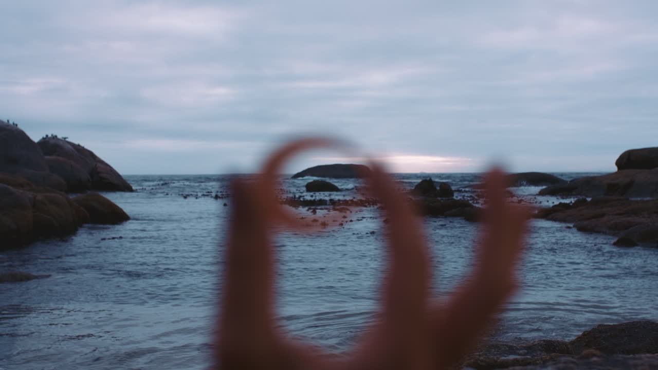 구름진 해변 해변에서 조개 ⁇ 데기를 들고 있는 손의 근처
