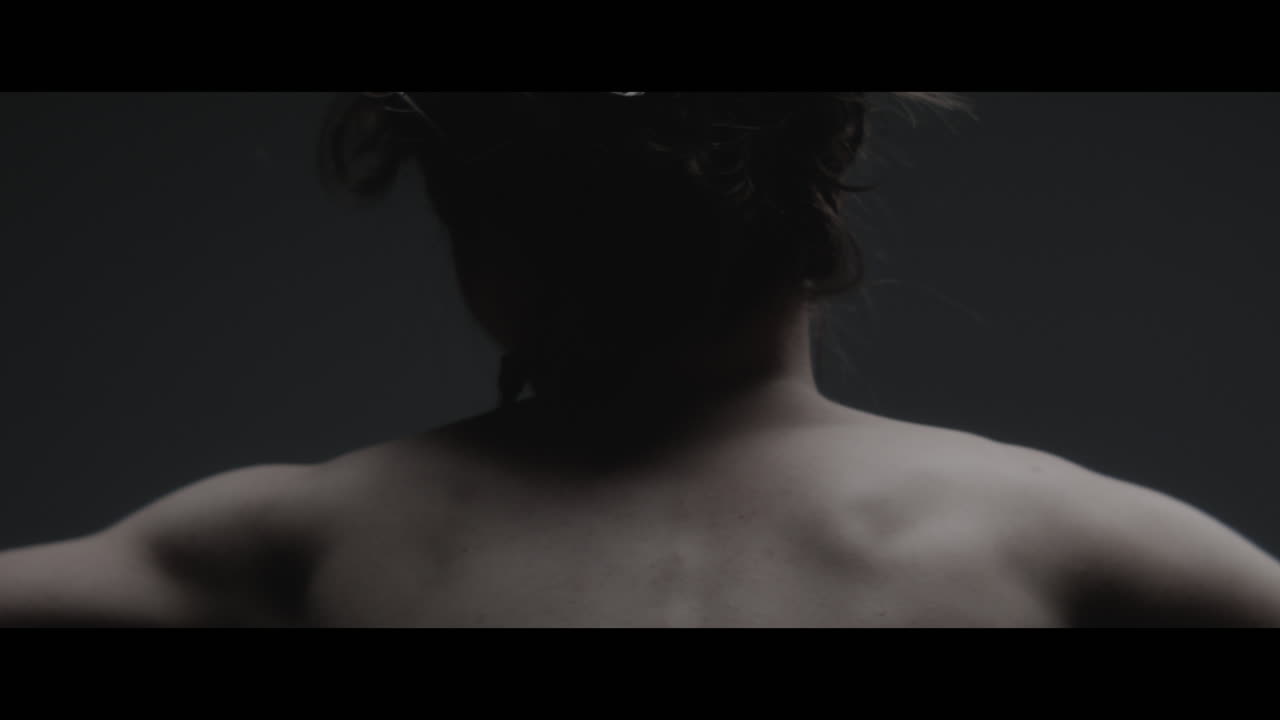 A woman dressed as mother nature moves slowly in a dance-like motion