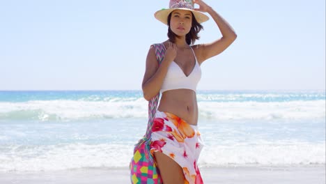 pretty trendy young woman posing on a windy beach