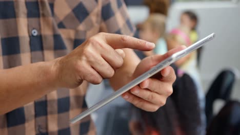 sección media de un profesor masculino usando una tableta digital en el aula 4k