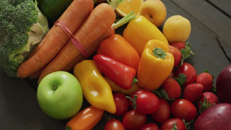 Video of fresh apples, carrots, peppers and tomatoes on black background