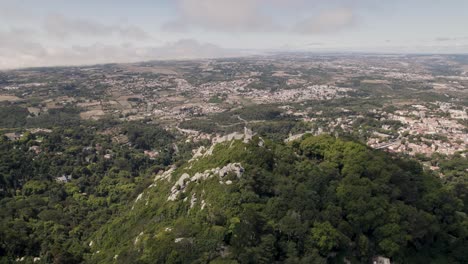 historic medieval stone ruins of castle of the moors in sintra portugal, aerial pan shot